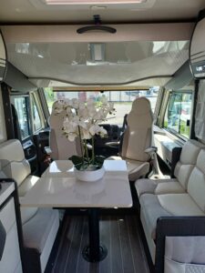 View of the front cabin of the CI 67 integral motorhome, with a dining area decorated with a plant on the table