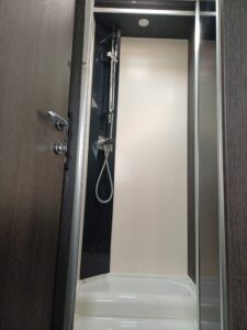 Chuveiro moderno com acabamento elegante em motorhome CI 67 integral, equipado com chuveiro de aço inoxidável