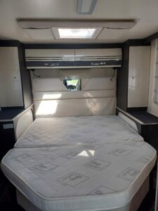 Chambre avec un lit double confortable et des rangements intégrés dans un camping-car CI 67 intégral