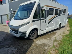 Vista lateral da autocaravana CI 67 completa, mostrando as suas janelas e carroçaria elegante.